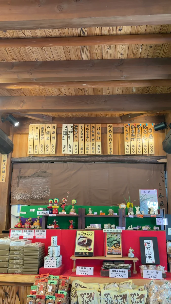 壁に並んだ木のメニュー札。ざる800円、やまかけ1,300円、かもざる1,700円など