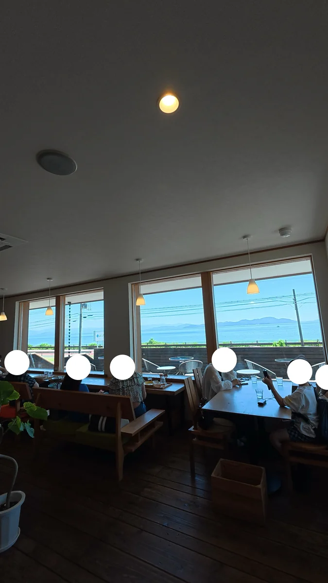 窓の向こうは琵琶湖と対岸の山（左）／店内の引き。窓側の列にカウンター席がある（右）