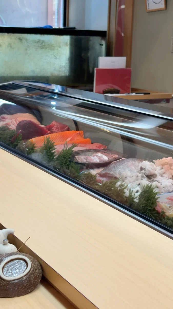 (左)カウンター席。正面がネタケースで、その奥が厨房です/(右)ケースの中。ここから、その日のお造りが出てきます