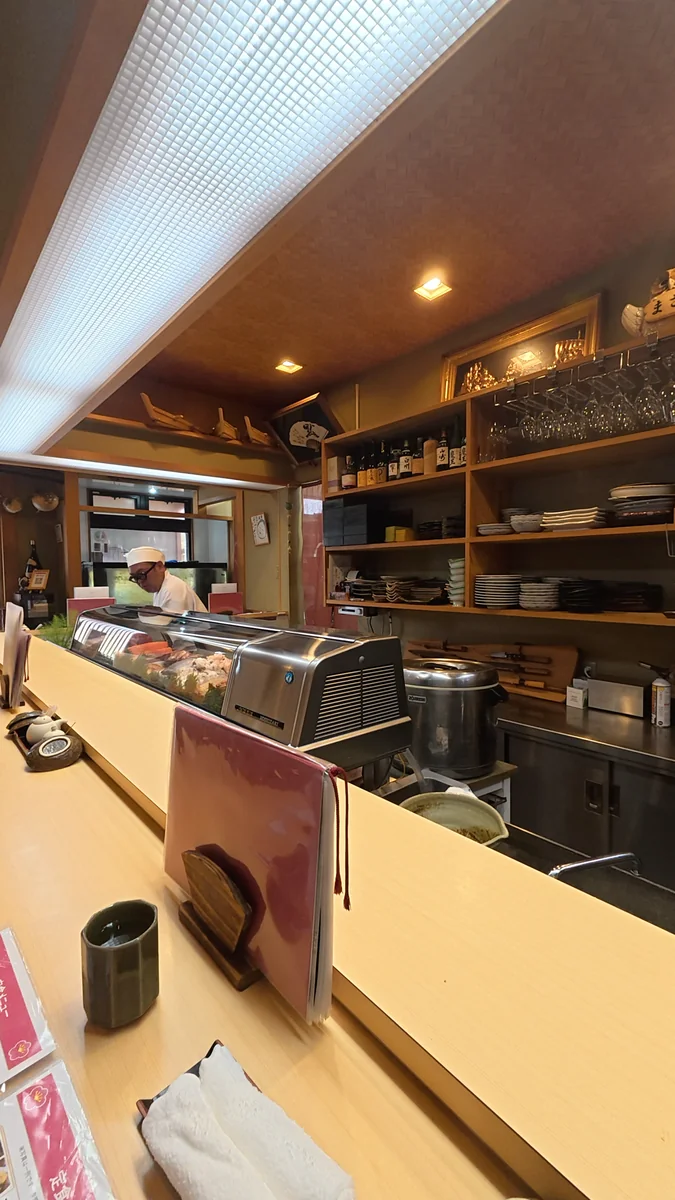 (左)カウンター席。正面がネタケースで、その奥が厨房です/(右)ケースの中。ここから、その日のお造りが出てきます