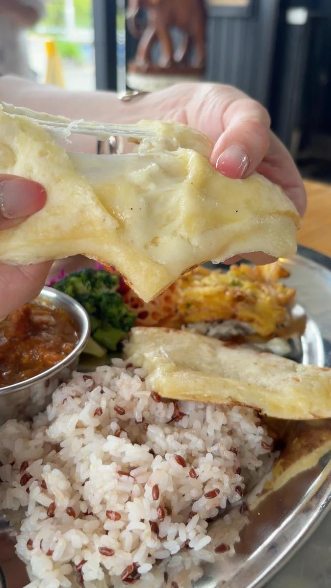（左）タンドール窯。生地を内側の壁に貼りつけて焼きます／（右）6月に入っていたチーズナン。2026年7月からは、標準がプレーンナンに変わりました