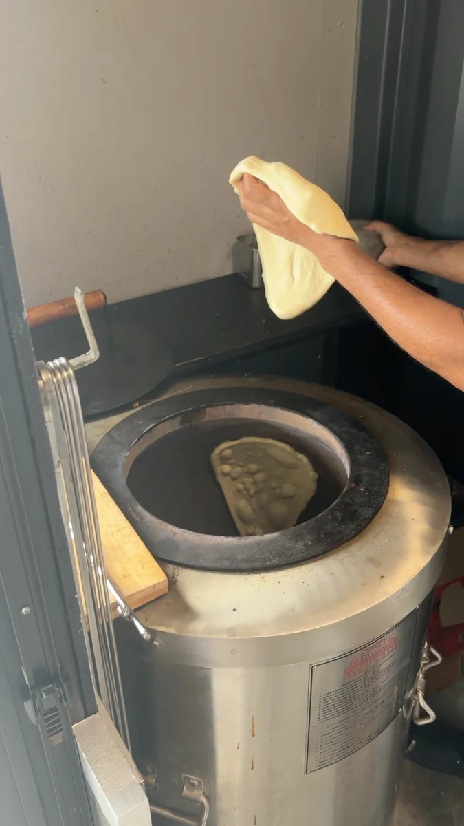 （左）タンドール窯。生地を内側の壁に貼りつけて焼きます／（右）6月に入っていたチーズナン。2026年7月からは、標準がプレーンナンに変わりました
